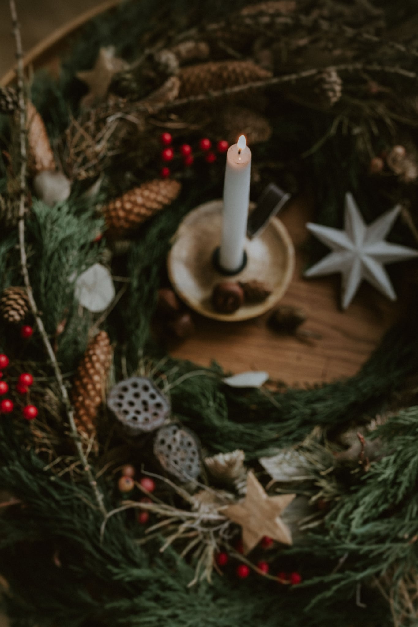 Detail vánočního věnce s hořící svíčkou